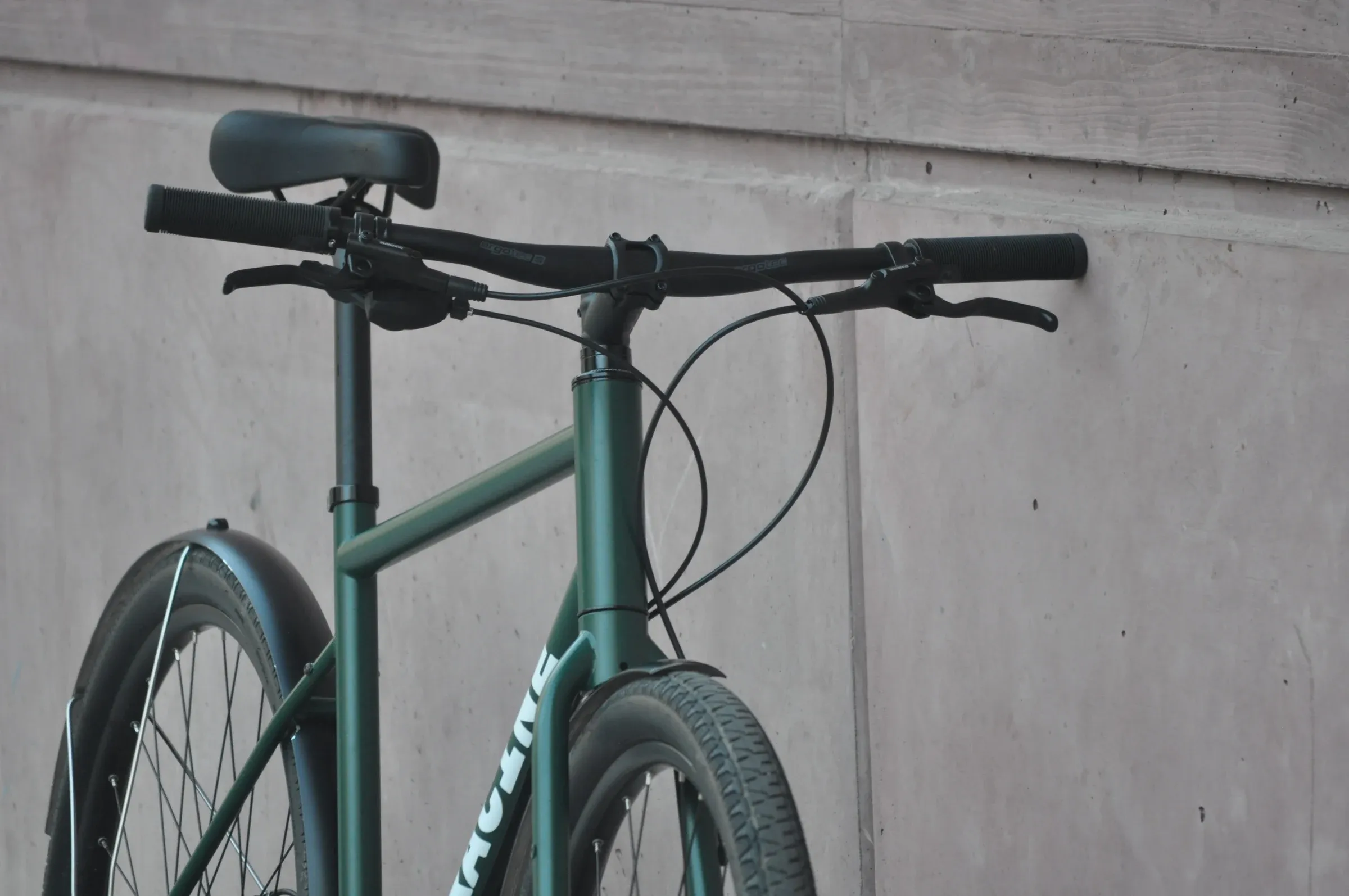 Détail du cadre vert mousse et du guidon drop bar d'un vélo urbain Vélos-Racine, vue rapprochée frontale