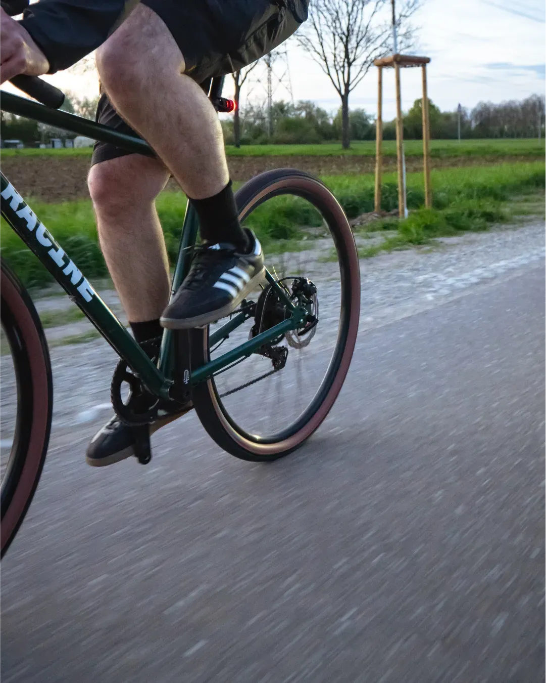 Cycliste en mouvement sur un chemin, vélo Racine vert, détail du pédalage