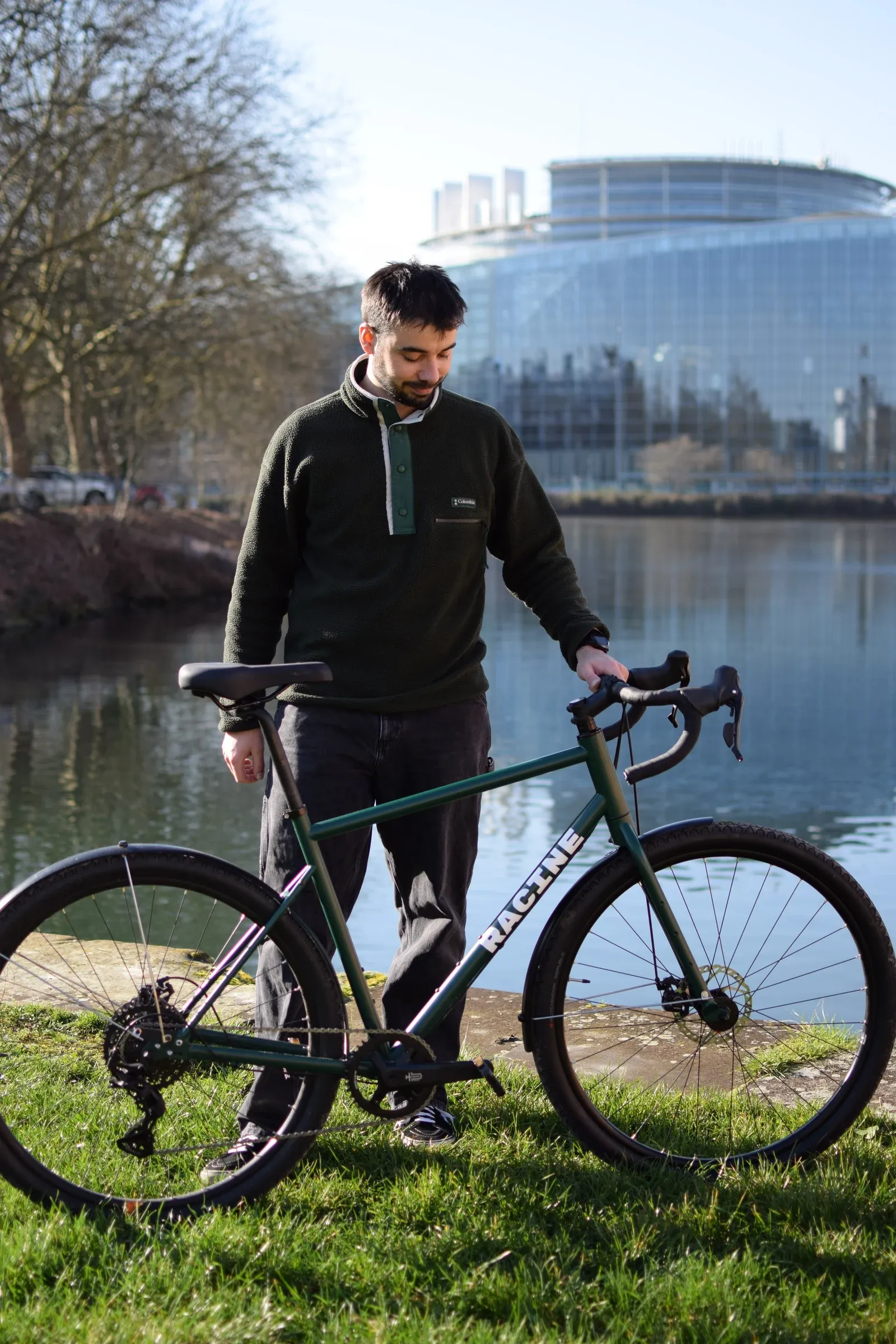 Victor Deweerdt avec le vélo Racine vert mousse au bord de l'Ill, Parlement européen à Strasbourg